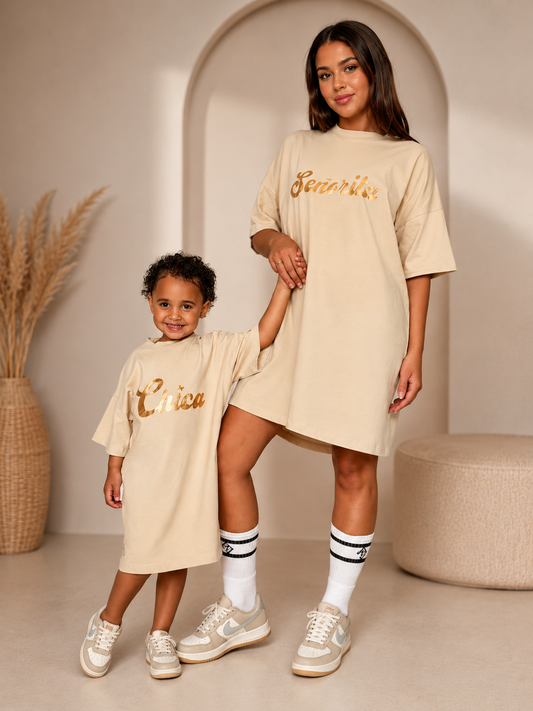 Vooraanzicht beige oversized T-shirt jurk met gouden opdruk 'Senorita' – vrouw hand in hand met klein meisje in dezelfde jurk